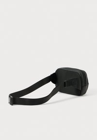 Čierna crossbody taška s textúrovaným povrchom, so zipsovým uzáverom a nastaviteľným popruhom. Kompaktný, obdĺžnikový tvar, vhodný na bežné nosenie.