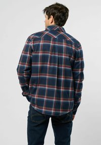Heren navy geruiten shirt met rode en blauwe ruitpatronen, een klassieke kraag, lange mouwen en knoopmanchetten, gemaakt van geweven stof.