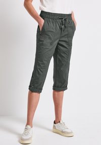 Khaki cropped broek met een elastische tailleband, trekkoord en opgerolde manchetten; beschikt over zijzakken en een gladde stofstructuur.