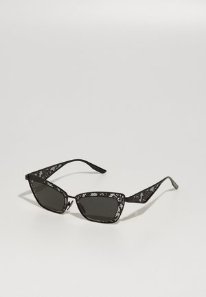 Mustat aurinkolasit, joissa on geometrinen muotoilu. Häivähdyksellinen kuvio varren osissa ja tummat linssit. Viistot kehykset luovat terävän, modernin siluetin.