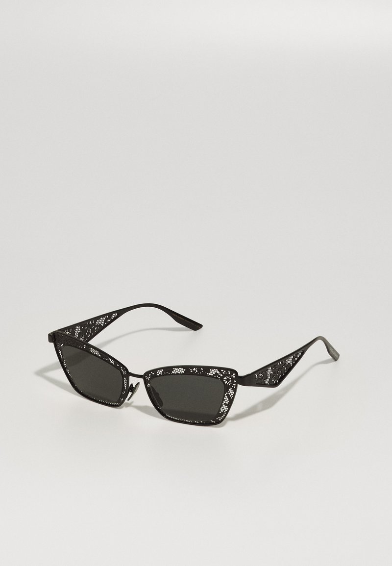 Black sunglasses with a geometric design. Lattice-patterned temples and dark lenses. Angled frames create a sharp, modern silhouette.
