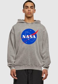 Felpa grigia realizzata in tessuto morbido, con un grande logo NASA blu con accenti rossi, maniche lunghe e una vestibilità comoda.