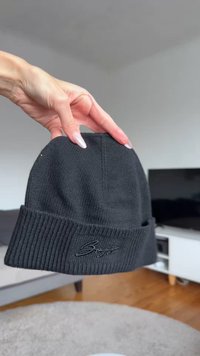 Black knit beanie with a ribbed cuff and a stitched logo on the front, featuring a smooth texture and fitted design.