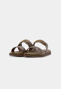 Brązowe płaskie sandały z teksturowanymi paskami i złotymi metalowymi detalami, przedstawione na białym tle.