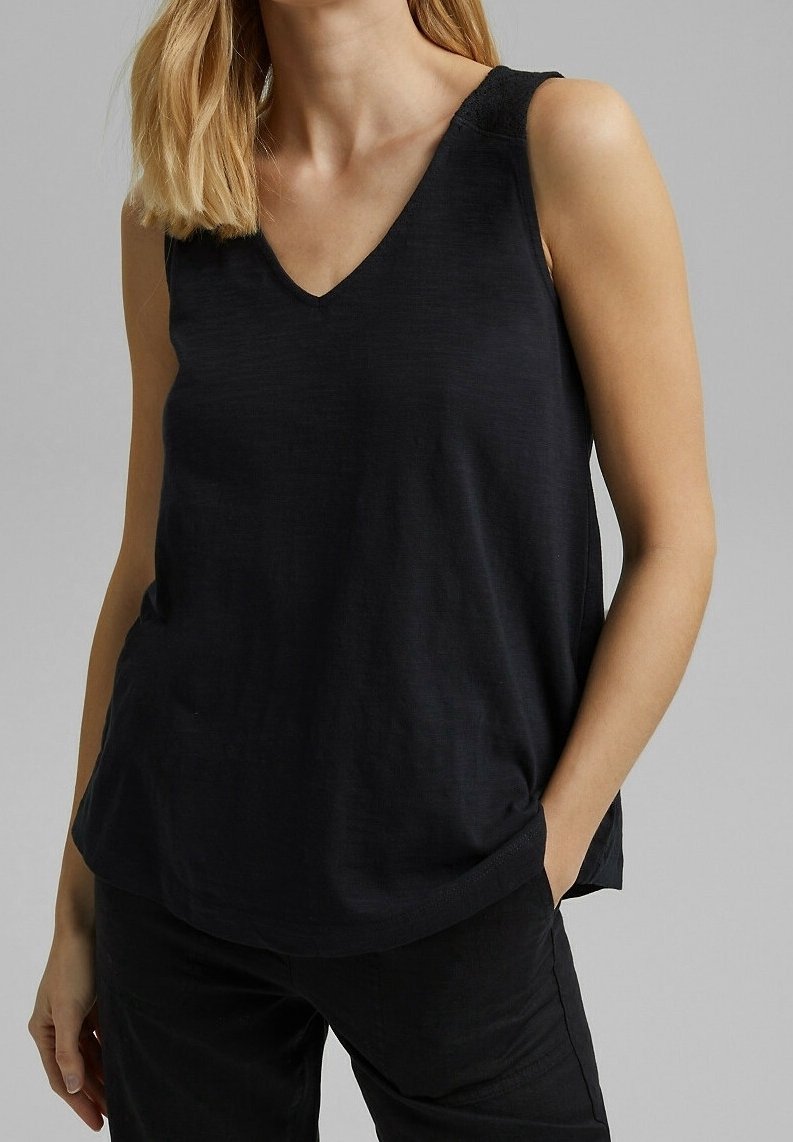 Svart ärmlös topp med V-ringning, tillverkad av lätt tyg. Har en avslappnad passform och subtila texturerade detaljer vid axlarna.