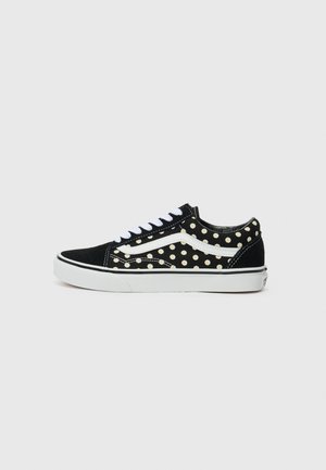 Schwarze Wildleder Sneaker mit weißen Punkten, weißer Gummisohle und weißen Schnürsenkeln. Mit dem charakteristischen seitlichen Streifen-Design von Vans.