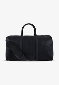 Bolsa de lona negra con un patrón de cuadros texturizado. Cuenta con asas dobles y una correa de hombro desmontable con acolchado.