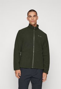 Veste en polaire verte avec col haut, fermeture éclair intégrale, deux poches latérales et détail de logo sur la poitrine. Texture douce et design confortable.