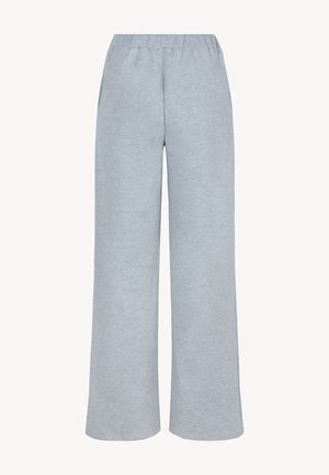 Jasnoszare, szerokie spodnie dresowe z elastycznym pasem i bocznymi kieszeniami na białym tle.