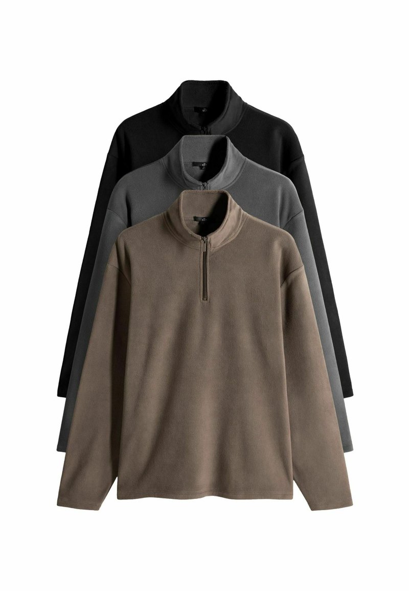 Rude kailiniai rudenio, pilkos ir juodos spalvos. Kiekvienas turi pusiau užtrauktuką ir ilgomis rankovėmis su minkšta, tekstūruota paviršiumi.