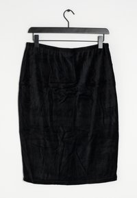 Svart midi kjol gjord av ett mjukt, texturerat tyg. Har en slät midjeband och hänger på en svart galge mot en vit bakgrund.