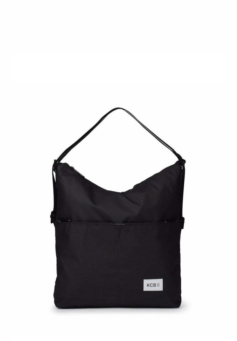 Sac à bandoulière noir rectangulaire avec une seule sangle, une poche avant et une petite étiquette logo rectangulaire portant l'inscription "KCB" dans le coin inférieur.