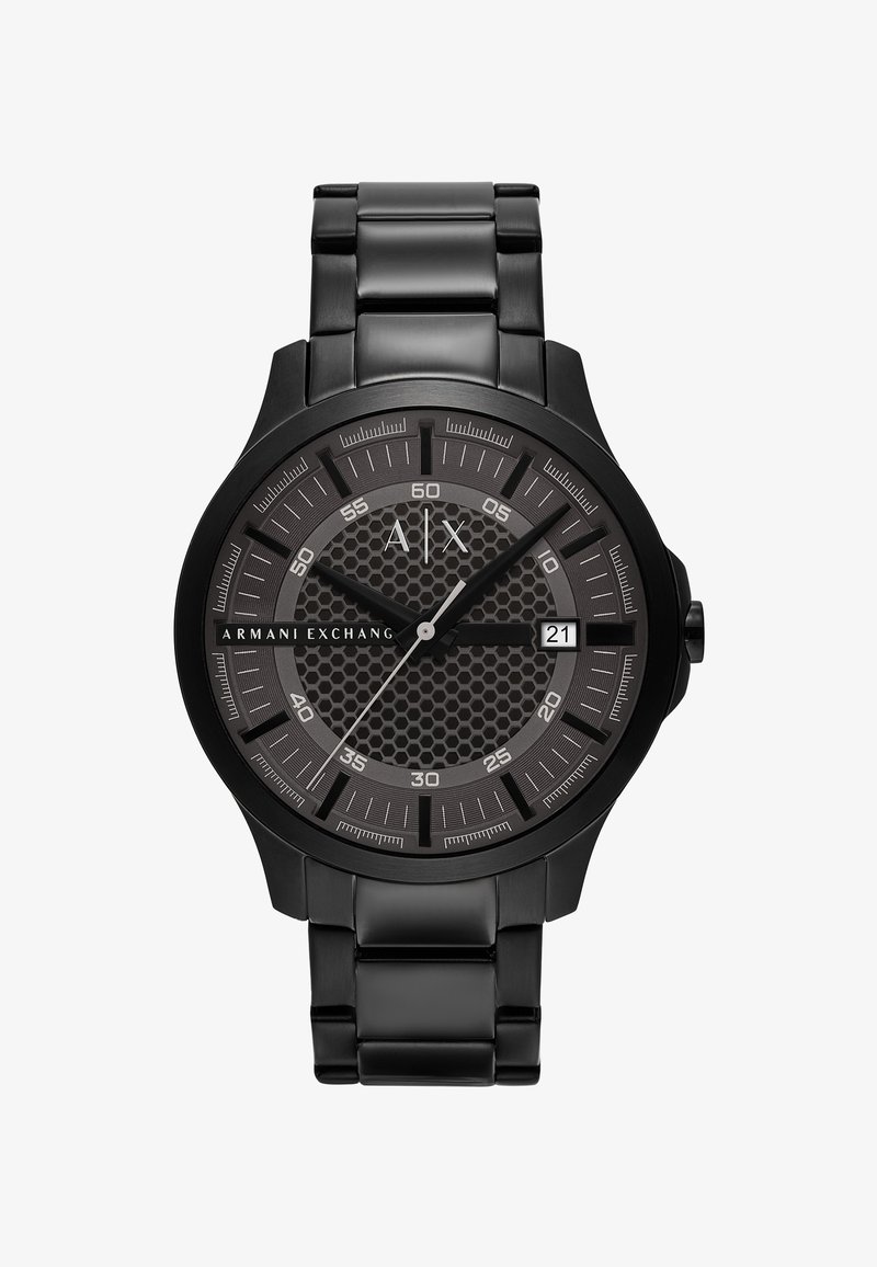 Musta roostevaba terasest kell, millel on tekstureeritud kuusnurkne nägu, hõbedased aktsendid, helendavad käed ja kuupäevanäidik kell 3.