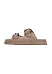 Sandali in suede beige con doppie cinghie ad ardiglione, suole piatte e lati aperti. Texture morbida e design minimalista per comfort e traspirabilità.