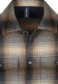 Geruite blouse met een mix van beige, bruin en blauwe kleuren. Gemaakt van een textuurstof met een kraag en twee knopen.
