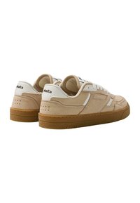 Sneakers z beżowym zamszowym wierzchem, białymi skórzanymi akcentami i gumową podeszwą. Posiada tonalne przeszycia oraz logo na pięcie.