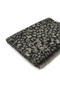 Tkana narzuta w kolorze czarnym i kremowym z fakturowanym wzorem w leoparda. Krawędzie ozdobione frędzlami dla dodatkowej tekstury.