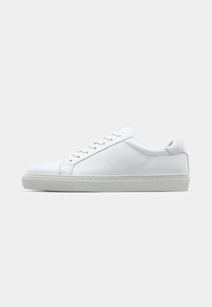 Sneaker blanche avec une tige en cuir lisse et un profil bas. Présente un bout arrondi, six œillets et une semelle en caoutchouc texturé.