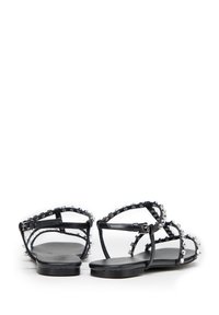 Zwarte leren sandalen met meerdere dunne banden en kristalaccenten, platte zool, open achterkant en een minimalistisch ontwerp.