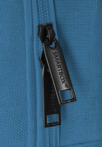 Primo piano di due cursori neri con doppia cerniera su tessuto blu strutturato, ciascun cursore inciso con il nome del marchio "SMARTBOX".