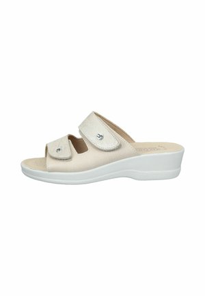 Beige Slip-On-Sandale mit zwei verstellbaren Klettverschlüssen und einer niedrigen weißen Keilsohle, die auf Komfort und Unterstützung ausgelegt ist.