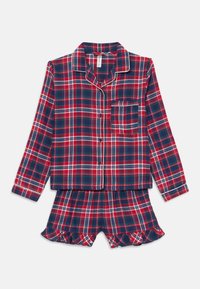 Punase ja tumesinine ruuduline öösärkide komplekt, millel on pikkade varrukatega nööpidega ülikond ja volangiga lühikesed püksid. Omab valget äärist kaeluse ja tasku ääres.