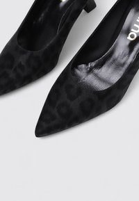 Escarpins noirs à bout pointu avec une finition mate et un subtil imprimé léopard. Dotés d'un petit talon carré et d'une doublure intérieure lisse.