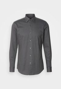 Chemise habillée homme à manches longues gris foncé avec fermeture boutonnée devant et col pointu sur un fond clair uni.