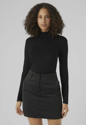 Black long-sleeve turtleneck top paired with a dark gray corduroy mini skirt featuring vertical ribbed texture and side pockets.