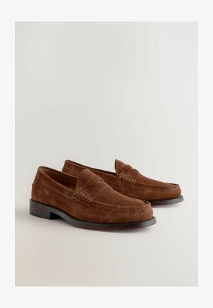 Brune ruskindsloafers med et syet design, rund tå og en lav sort hæl. Overdelen har en hævet accent langs sømmen.