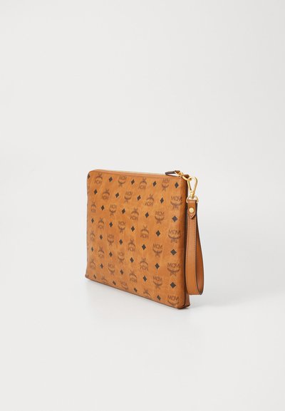Pochette en cuir tan avec un motif de logo répété, quincaillerie dorée et une sangle de poignet amovible. Texture lisse et forme rectangulaire.