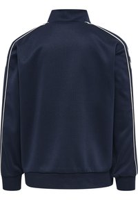 Chaqueta deportiva de color azul marino con un acabado texturizado, franjas laterales blancas y cuello alzado. Presenta puños y dobladillo elásticos.