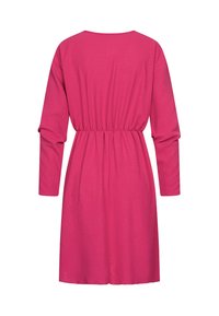 Vaaleanpunainen, pitkähihainen mekko pyöreällä pääntiellä ja joustavalla vyötäröllä. Valmistettu sileästä kankaasta, siinä on hieman väljempi istuvuus, ja se ulottuu polven yläpuolelle.