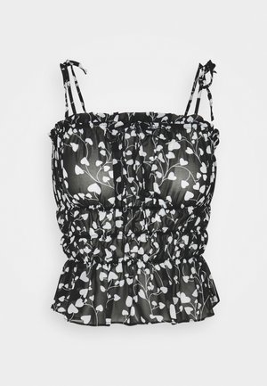 Haut court à imprimé floral noir et blanc avec bretelles réglables, texture froncée et ourlet à volants. Confectionné dans un tissu léger et transparent.