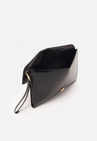 Černá lakovaná kabelka na zip se zlatými prvky. Interiér je otevřený, s hladkým povrchem a elegantním designem.