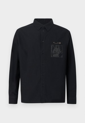 Must musta pika varrukaga pluus, millel on ees tasku ja graafiline trükk. Tasku lähedal on turvanõela aksessuaar.