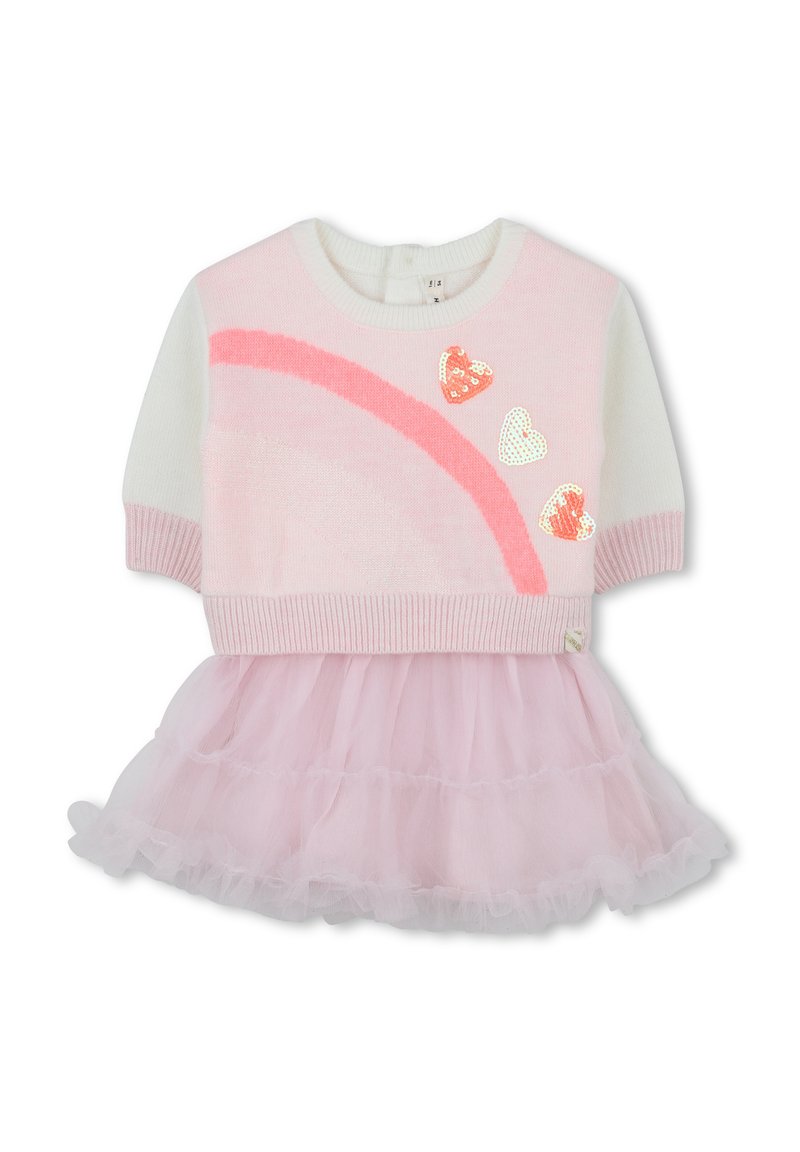 Top en tricot rose et blanc avec un design arc-en-ciel et des cœurs en sequins, associé à une jupe en tulle rose superposée. Tissus doux et texturés.