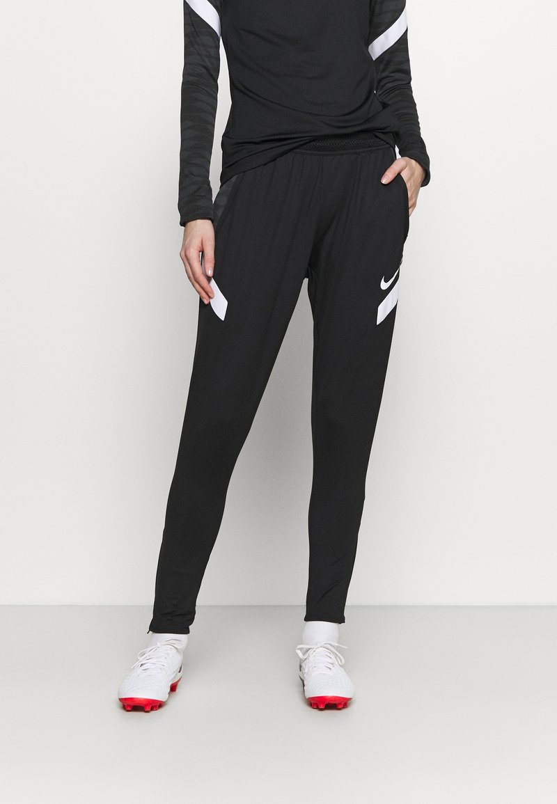 Svarta atletiska byxor med vita sidodetaljer och midjeband med dragsko, tillverkade av ett lätt material, med en slim fit-design.