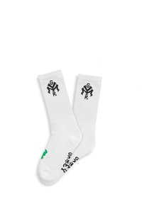 Calcetines blancos con textura acanalada, con un logo negro en el puño y acentos verdes en la puntera, y texto impreso en la suela.