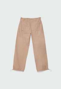 Pantalones de algodón beige con cintura elástica, dos bolsillos traseros y dobladillos ajustables con cordón. Textura suave, diseño de corte holgado.