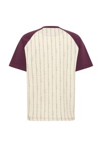 Κοντομάνικο μπλουζάκι με εκρού σώμα και μπορντό ραγκλάν μανίκια, με διακριτικό επαναλαμβανόμενο μοτίβο κειμένου στην πλάτη.