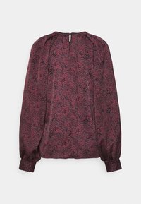 Bluzka z długim rękawem w głębokim burgundowym kolorze z teksturowanym wzorem. Zebrane ramiona i elastyczne mankiety podkreślają luźny krój. Zapięcie na plecach w formie otworu w kształcie klucza.