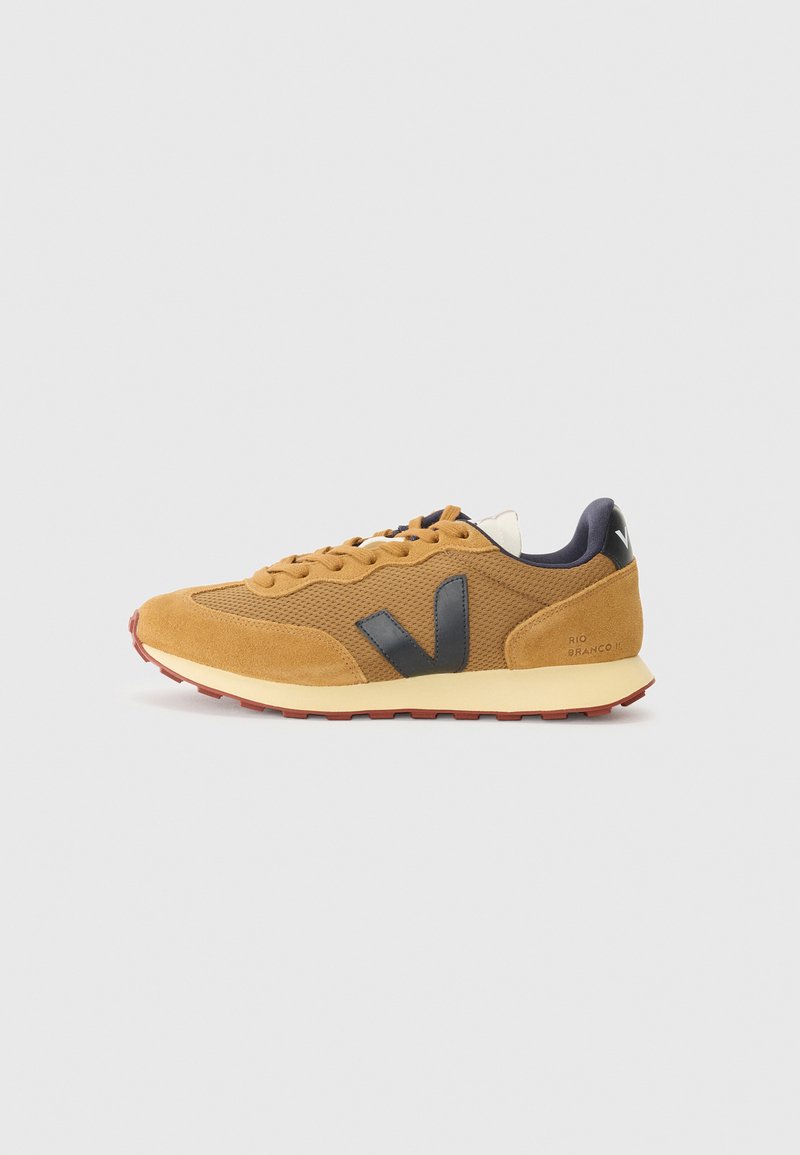 Sneaker in suede marrone con pannelli in rete, dettagli neri e suola in gomma texturizzata. Presenta un logo sul tallone e un design con lacci.