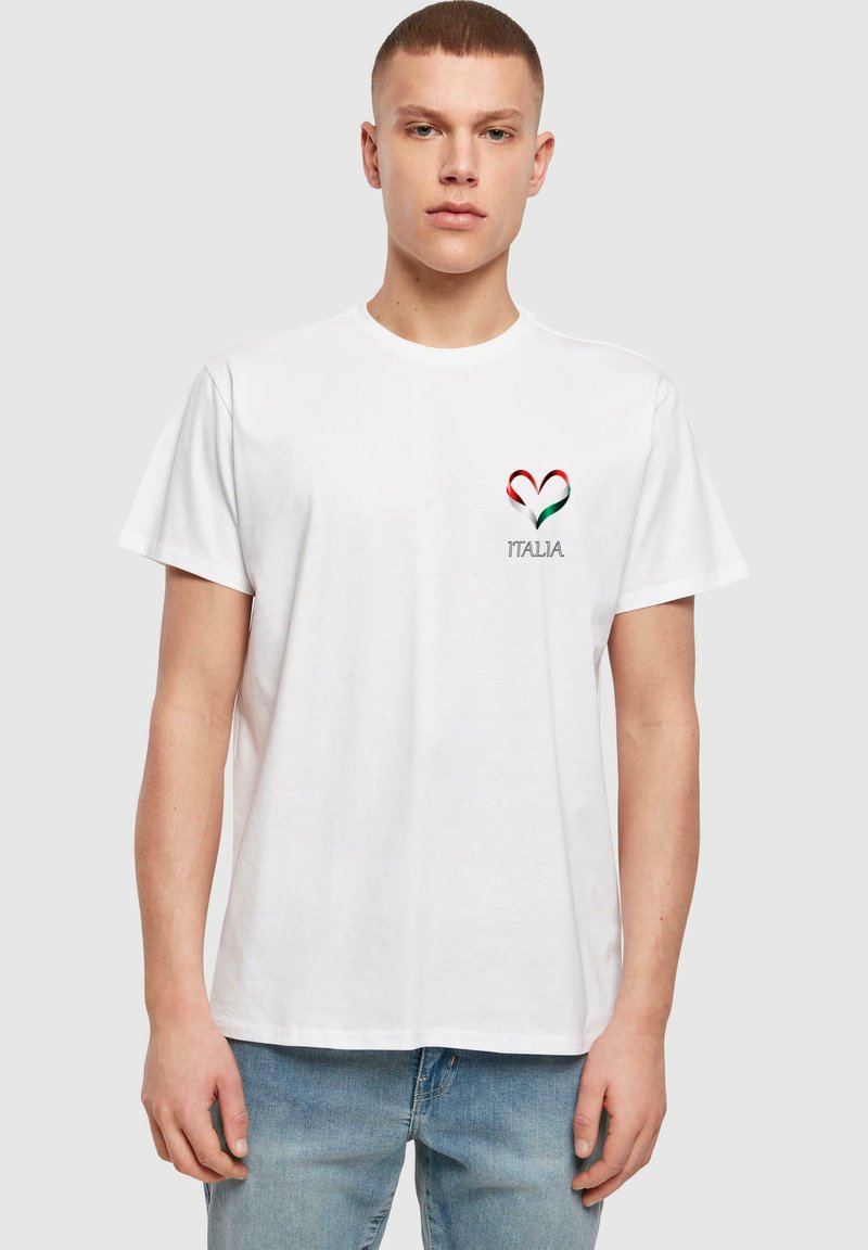 Hvid bomulds T-shirt med et rødt, grønt og hvidt hjerte-design og teksten "ITALIA" nedenunder, kortærmet og med en klassisk pasform.