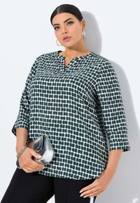 Groen en wit gemusterde blouse met een kraag, driekwart mouwen en een losse pasvorm, gecombineerd met een zilveren clutch.