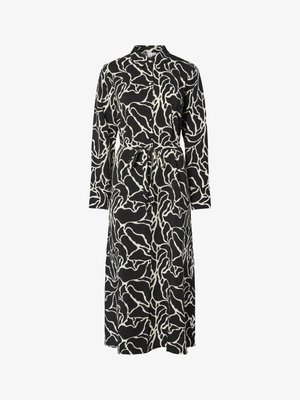 Vestido de mangas largas en negro con un patrón abstracto en blanco, con cuello tipo camisa, cinturón a la cintura y silueta fluida.