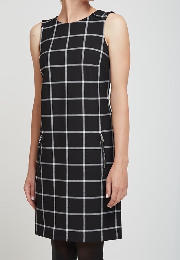 Robe sans manches noire avec un motif en damier gris, dotée de poches zippées à l'avant et d'une coupe structurée. Texture de tissu lisse.