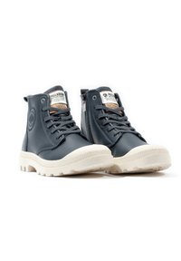 Zapatillas altas de color azul oscuro, hechas de cuero, con una suela de goma blanca, cordones, un zipper lateral y una marca en la lengüeta y el talón.
