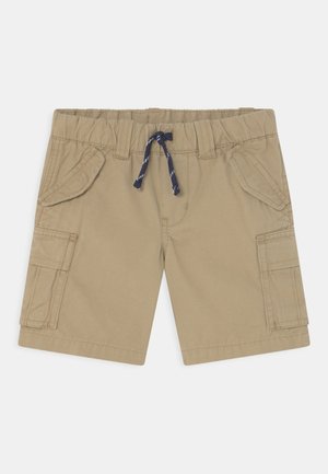 Pantalones cortos cargo beige para niños con cinturilla elástica, cordón azul marino, bolsillos delanteros con solapa y bolsillos laterales cargo sobre fondo blanco.