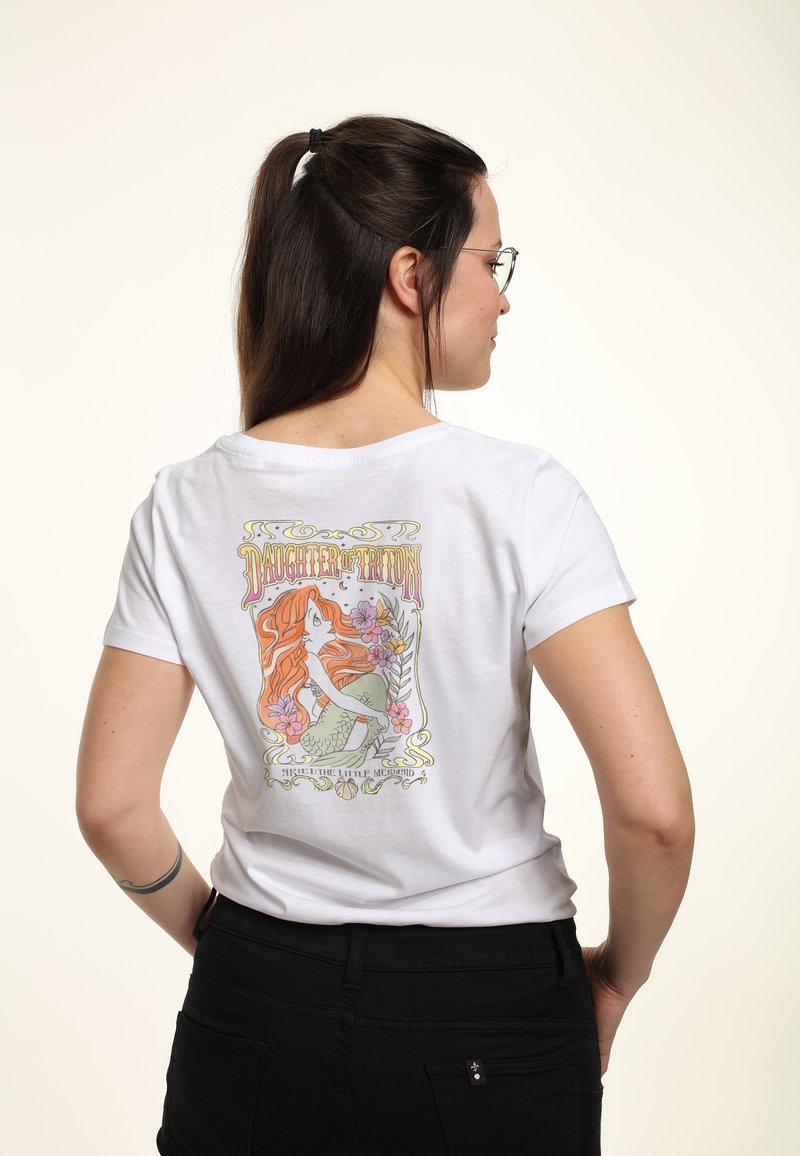 T-shirt en coton blanc avec un graphique coloré au dos représentant une sirène entourée de fleurs, avec le texte "Fille de Triton". Manches courtes.